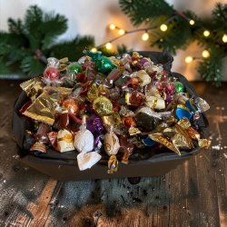 Gavekurv til jul og medarbejdere: Stemningsfuldt s�sonbillede af den �bne juleslikkurv, anrettet i en varm decemberops�tning under butikkens glitrende og hyggelige lysk�der.
