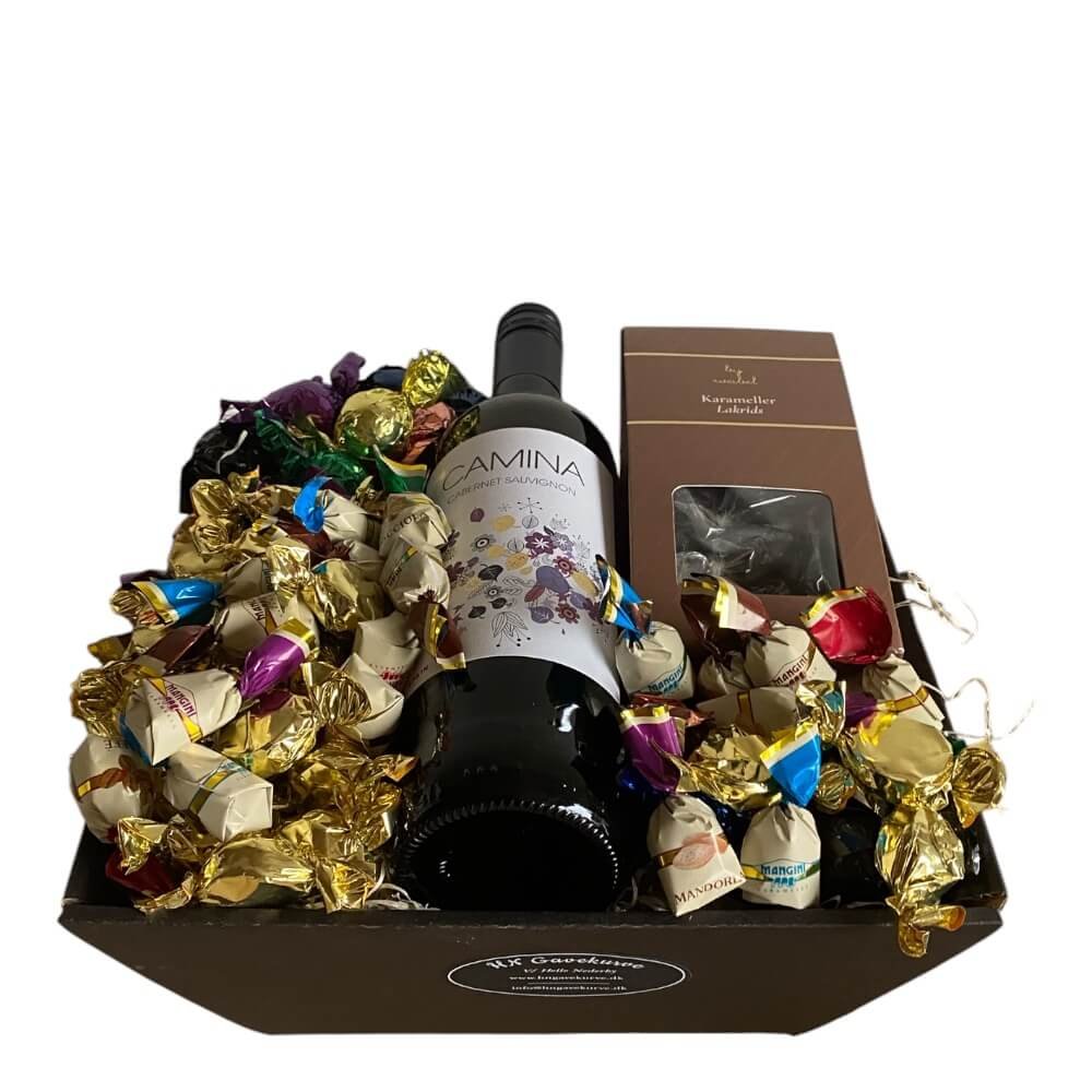Gavekurv med vin og chokolade: Flot anrettet gavehilsen i cellofan sp�kket med Camina r�dvin, 250g Cocoture chokoladekugler, guldindpakkede chokoladekarameller og Weibel lakridskarameller p� tr�uld