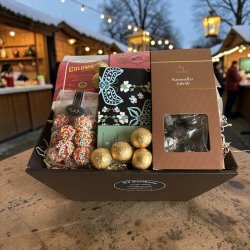 Gavekurv til jul og firmagave: Flot julegavekurv sp�kket med chokolade, kaffe og slik, fotograferet i hyggelig julestemning med gran og julepynt i baggrunden