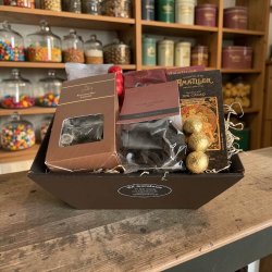 Gavekurv til firmagave: Pr�sentabel og luksuri�s gavekurv sp�kket med kvalitetschokolade og gourmetlakrids, fotograferet i et lyst og indbydende milj� for at fremh�ve de stilrene emballager