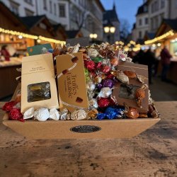 Gavekurv til jul og medarbejdere: Stemningsfuldt s�sonbillede af den �bne juleslikkurv, anrettet i en varm decemberops�tning under butikkens glitrende og hyggelige lysk�der.