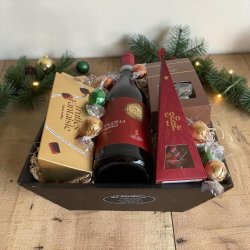Julegavekurv som firmagave eller eksklusiv julehilsen: Stemningsfuldt produktbillede af den sl�jfepyntede og f�rdigpakkede julekurv, anrettet st�ende indend�rs i butikkens hyggelige december udstilling