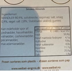 Varedeklaration og ingrediensliste p� Weibel r�gede mandler: T�t og overskueligt n�rbillede af den fulde indholdsfortegnelse, allergener og n�ringsv�rdier p� den hvide papir etiket.