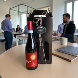 Vingave som eksklusiv receptionsgave, firmagave eller jubil�umshilsen: Indbydende produktbillede af de to r�dme Ca' Vegar flasker anrettet p� et flot festbord indend�rs i butikkens udstilling. 